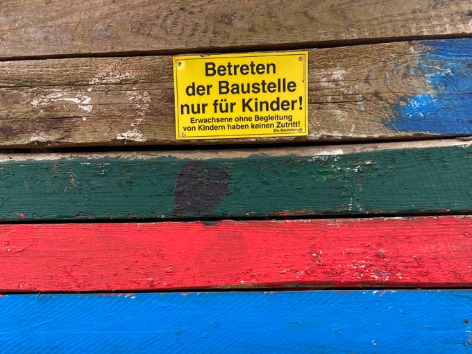 Zaun mit Schild: "Betreten der Baustelle nur für Kinder!"