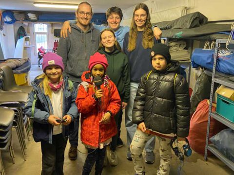 Gruppenfoto der Kutterleute vom Segelverein Altona Övelgönne zusammen mit den Kindern der Radiofüchse mit Mikrofon, Aufnahmegerät und Kopfhörern
