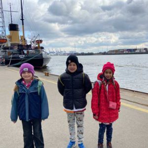 Zwei Mädchen und ein Junge stehen am Hamburger Hafen