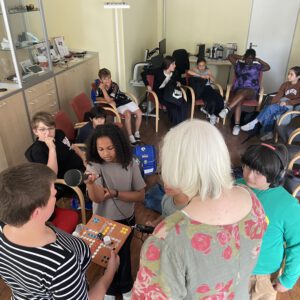 Katja Löffler zeigt Kindern ein Brettspiel für blinde Menschen