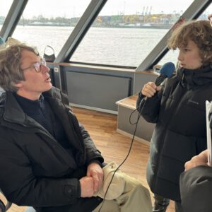 Zwei Kinder interviewen Peter Feddersen auf einer HADAG Fähre