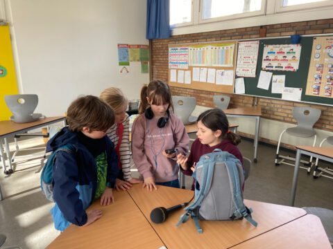 Kinder in einem Klassenzimmer untersuchen das Aufnahmegerät