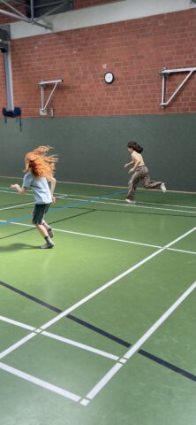 Zwei Kinder rennend in einer Turnhalle